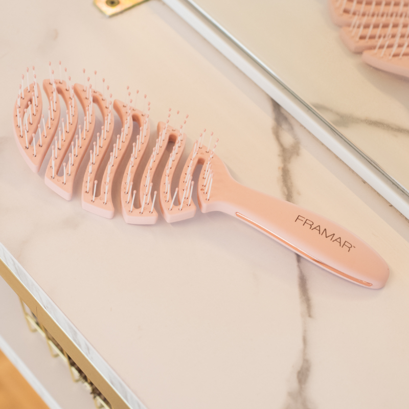Elegant champagne coloured Framar Flex Brush on a marble salon countertop