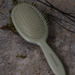 Close up of the flexible bristles and sage green handle of the Framar Birch detangle brush