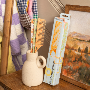 Three pastel-coloured Framar Dreamweaver combs with long stainless steel pintails in a decorative vase