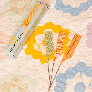 Framar Quilted Dreamweaver combs and packaging laid out on a quilted background showing the professional kit