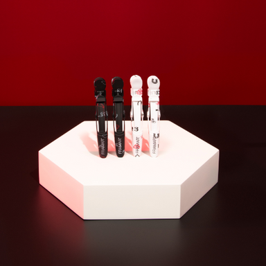 Professional display of black and white Framar Get Lucky Gator Grips on a salon pedestal