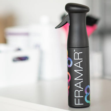 Side view of Framar Myst Assist black continuous mist spray bottle used in a professional salon