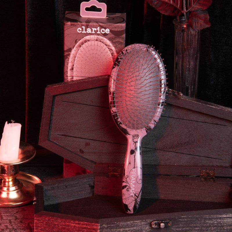 Framar Clarice detangle brush shown standing in a gothic-themed salon display
