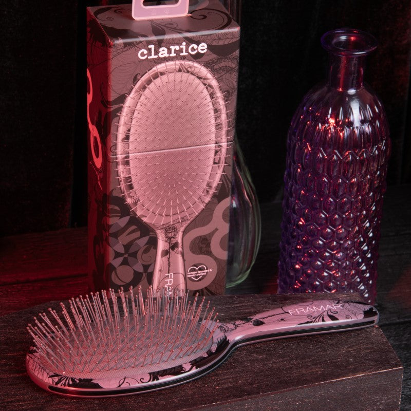 Professional detangle brush with gothic pattern displayed in a salon setting