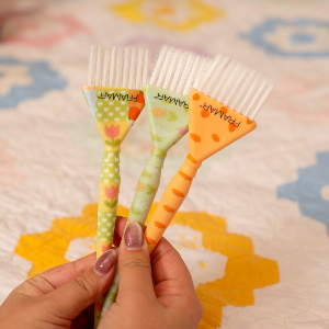 Hairdresser holding the Framar Quilted Triple Threat colour brushes for precision application