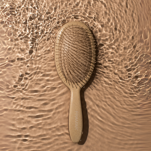Eco-friendly Framar Terra brush in Canvas Ecru on a water ripple background for salon detangling