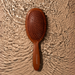 Professional Framar Terra detangle brush in Terracotta Clay against a water aesthetic