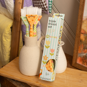 Professional Framar Quilted colour brushes displayed in a white vase on a salon trolley
