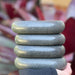 Professional therapist holding a stack of four Joiken x-large ovular massage stones