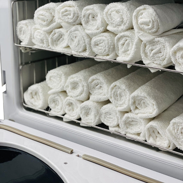 Interior view of the Joiken OPAL showing neatly stacked white hand towels on stainless steel racks