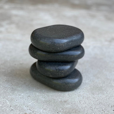 Stack of four Joiken x-large black ovular basalt massage stones for professional salon use