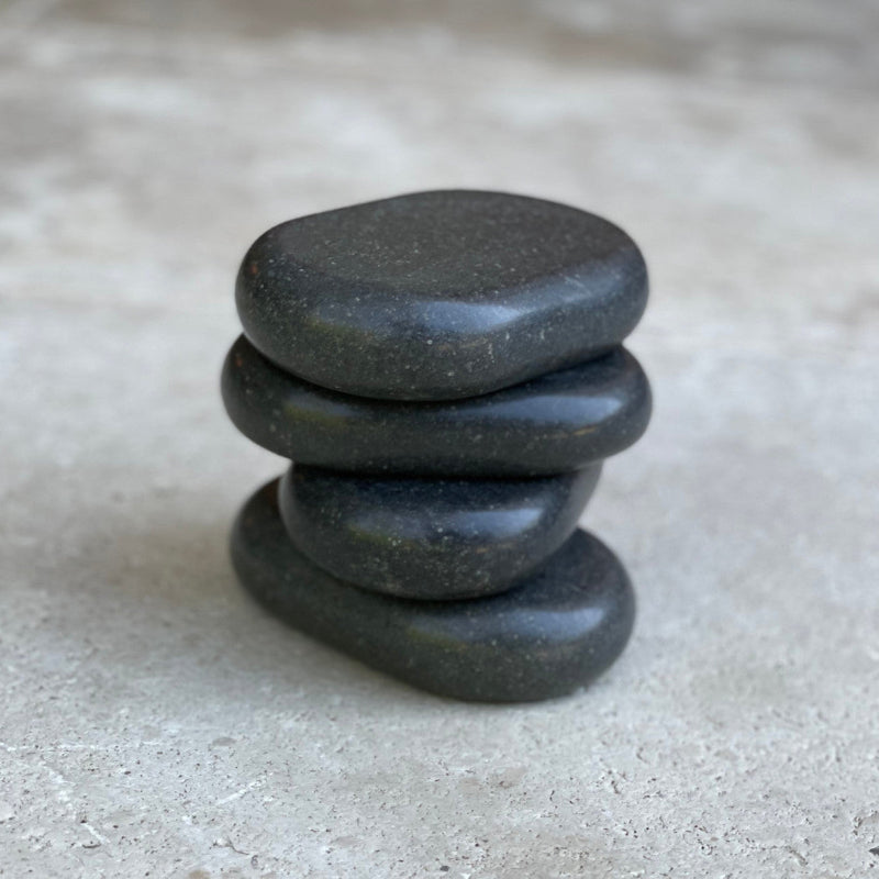 Stack of four Joiken x-large black ovular basalt massage stones for professional salon use