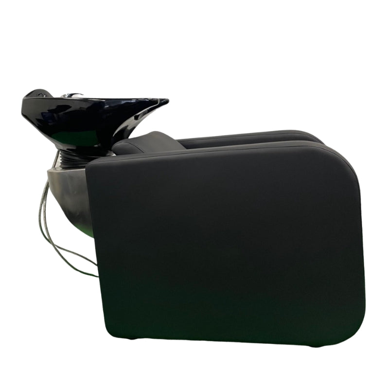 Side profile of the Karma Clunes black electric shampoo basin unit showing the sleek enclosed pedestal design