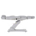 Side profile of the white Karma Inglewood electric treatment table in a flat position showing the heavy-duty base