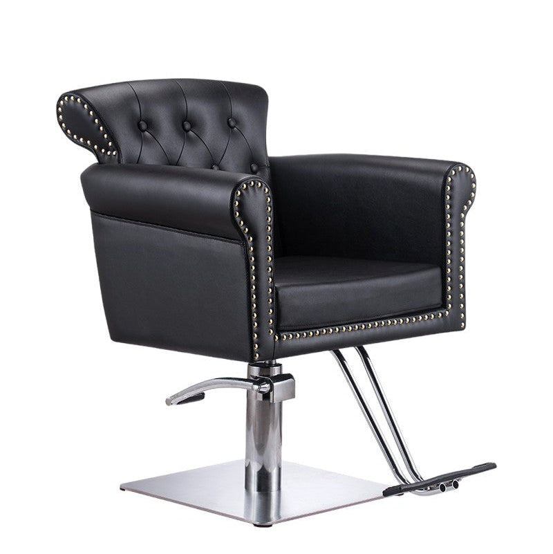 Front view of the Karma Thredbo black tufted salon chair with stud detailing and hydraulic base