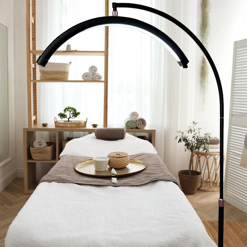 A high-resolution lifestyle shot featuring a sleek, white LED magnifying lamp positioned over a professional beauty bed in a modern Australian clinic setting